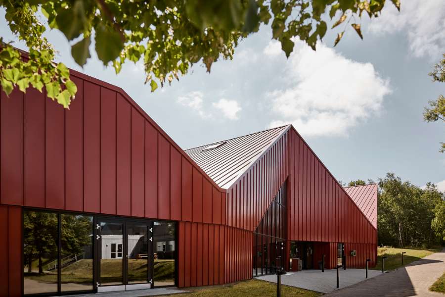 The sports center in Vestbjerg is clad with red steel profiles
